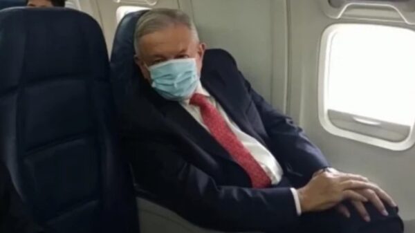 El presidente Andrés Manuel López Obrador usando cubrebocas durante un vuelo.